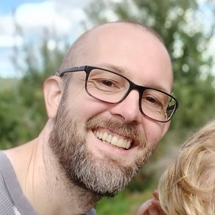 a man with beard and glasses smiles at camera